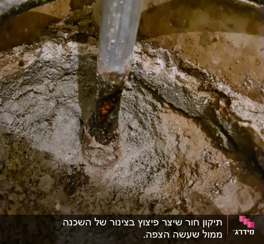 צינור מתכת חלוד בתוך קיר בטון